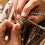 Owl fidget pendant held in hand showing the moving eye mechanism