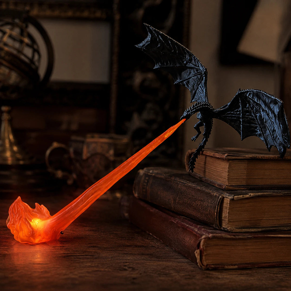 Black dragon with a red LED flame beside a stack of books