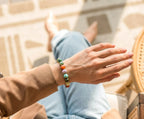 Indian agate bead bracelet worn with a tan sleeve and denim