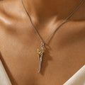 Two-tone hugging pendant necklace worn at the neckline